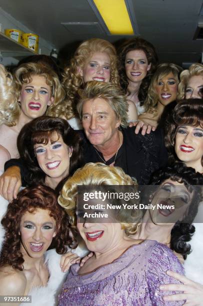 Rod Stewart is surrounded by cast members of the musical "La Cage aux Folles" as he drops in for a backstage visit during intermission at the Marquis...