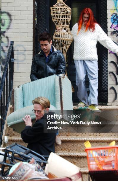 Robin Wright Penn, Colin Farrell and Dallas Roberts carry household goods out of an apartment building during filming of "A Home at the End of the...