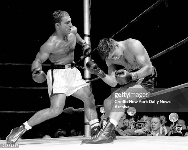 Rocky by TKO. Challenger Roland LaStarza instinctively but weakly raises his weary arms in defense as heavyweight champ Rocky Marciano cranks his...