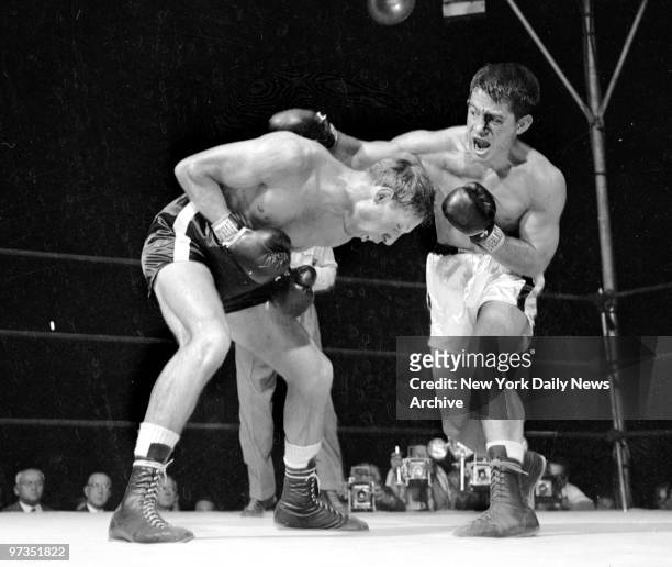 Rocky Graziano throws one of his vicious rights in the second round as Charley Fusari does a neat piece of ducking. Charley was not such a good...