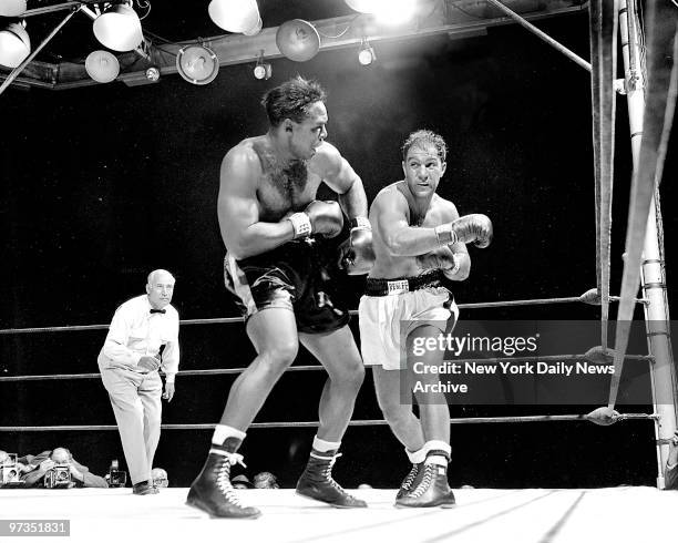 Rocky Marciano misses with a left as Archie Moore turns away during Yankee Stadium match..