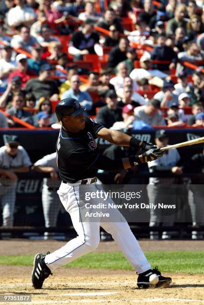 Roger Cede?o hits a dribbler in front of home plate to bring in a run for the New York Mets when the Florida Marlins' catcher Pudge Rodriguez...