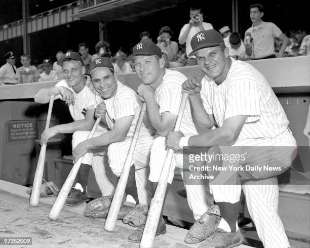 Roger Maris, Yogi Berra, Mickey Mantle and Moose Skowron pose in front of dugout.