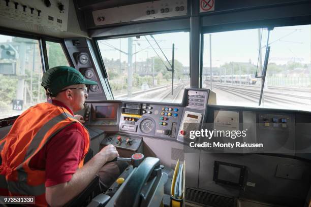 train driver in stationary locomotive on train tracks - train engineer stock pictures, royalty-free photos & images