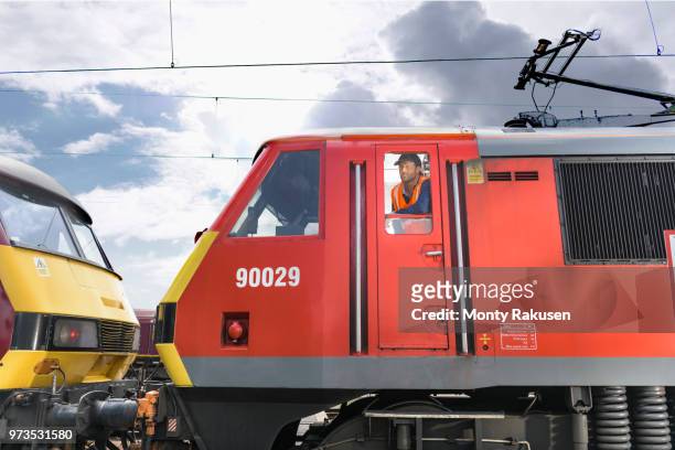 train driver in locomotive cab in train engineering factory - train driver stock pictures, royalty-free photos & images