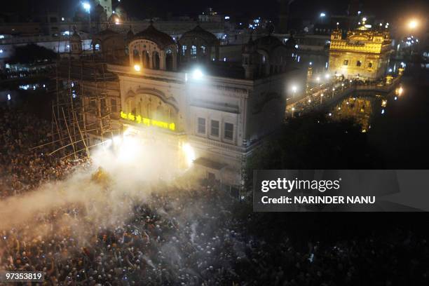 Indian Sikh devotees spray perfume on the Palki Sahib which carries The Guru Garnth Sahib in a procession from the Golden Temple to Sri Akal Takhat...