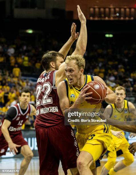 Luke Sikma of ALBA Berlin competes with Danilo Barthel of Bayern Muenchen during the fourth play-off game of the German Basketball Bundesliga finals...