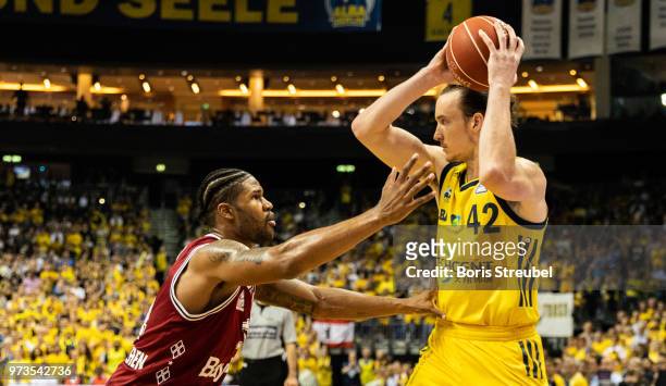 Dennis Clifford of ALBA Berlin competes with Devin Booker Bayern Muenchen during the fourth play-off game of the German Basketball Bundesliga finals...
