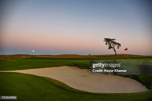 Course scenic view of a greenside bunker on the 13th hole as the moon rises during media day for the 2018 U.S. Open Championship at Shinnecock Hills...