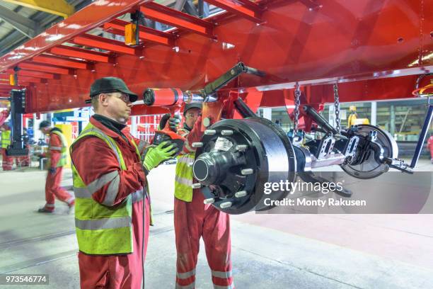 worker using torque wrench to fix electrical axle to chassis on production line in trailer factory - torque wrench stock pictures, royalty-free photos & images