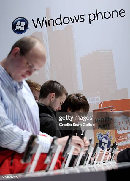 Visitors check out mobile phones using the Microsoft Windows mobile phone operating system at the CeBIT Technology Fair on March 2, 2010 in Hannover,...