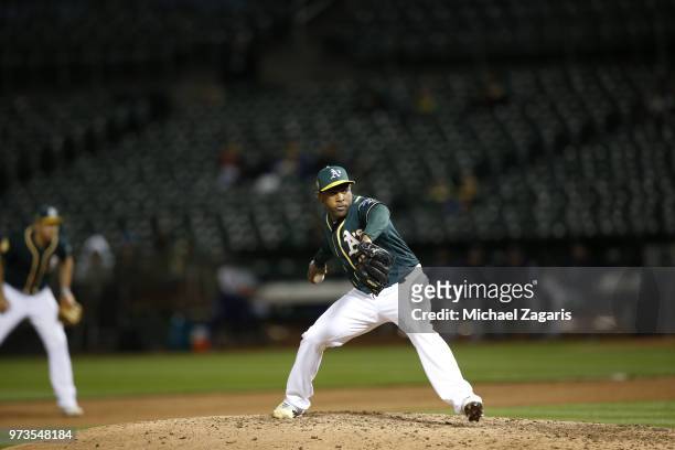 Santiago Casilla of the Oakland Athletics pitches during the game against the Seattle Mariners at the Oakland Alameda Coliseum on May 23, 2018 in...