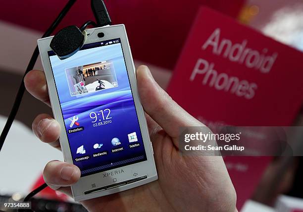 Stand host holds a Sony Ericsson XPERIA X10 mobile phone that uses the Android operating system at the Deutsche Telekom stand at the CeBIT Technology...