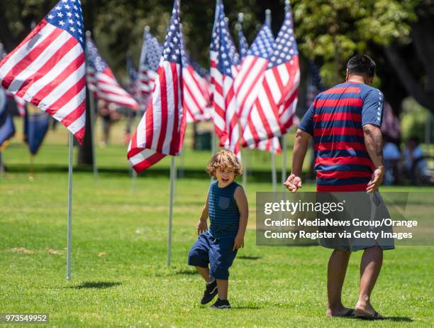 Ernie Solano, right, of Cypress plays with his step-son during the 23rd annual Flag Day celebration at Pearson Park in Anaheim on Sunday, June 10,...