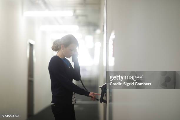 woman using telephone in office - sigrid gombert photos et images de collection