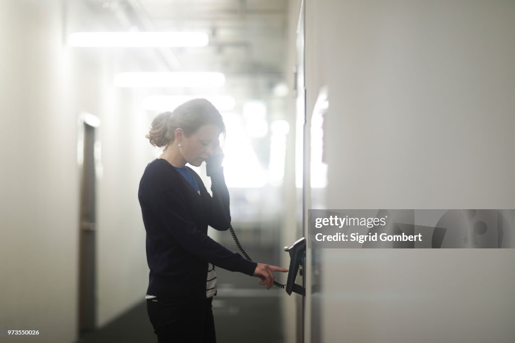 Woman using telephone in office