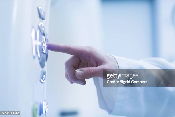 person using control panel of ct scanner, close-up - sigrid gombert stock-fotos und bilder