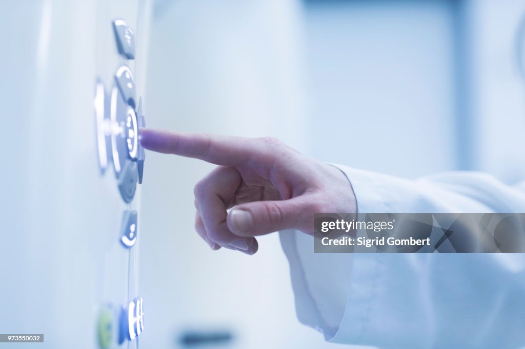 Person using control panel of CT scanner, close-up