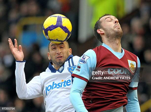 Portsmouth's Algerian player Nadir Belhadj vies with Burnley's Scottish forward Steven Fletcher during the English Premier League football match...