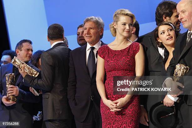 Actor Harrisson Ford, French TV host Virginie Efira and French actress Emma De Caunes pose on stage at the end of the 35th Cesars French film awards...