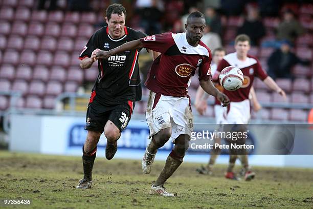 Abdul Osman of Northampton Town attempts to move away with the ball from Julian Alsop of Cheltenham Town during the Coca Cola League Two Match...
