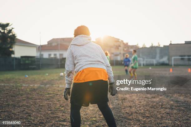 football players playing on football pitch - woman goalie stock pictures, royalty-free photos & images