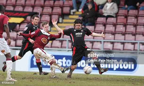 Billy McKay of Northampton Town shoots for goal past Andy Gallinagh of Cheltenham Town during the Coca Cola League Two Match between Northampton Town...