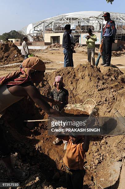 Labourers work outside the Jawahar Lal Nehru Stadium during a visit by Australian Foreign Minister Stephen Smith in New Delhi on March 2, 2010....