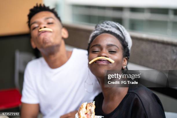 group of young people having fun in a restaurant - eating chips stock pictures, royalty-free photos & images