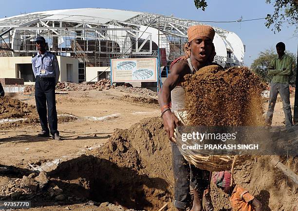 Labourers work outside the Jawahar Lal Nehru Stadium during a visit by Australian Foreign Minister Stephen Smith in New Delhi on March 2, 2010....