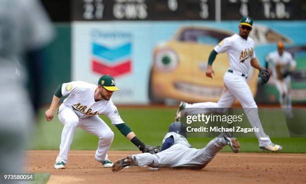 Jed Lowrie of the Oakland Athletics tags Andrew Romine of the Seattle Mariners out at second during the game at the Oakland Alameda Coliseum on May...