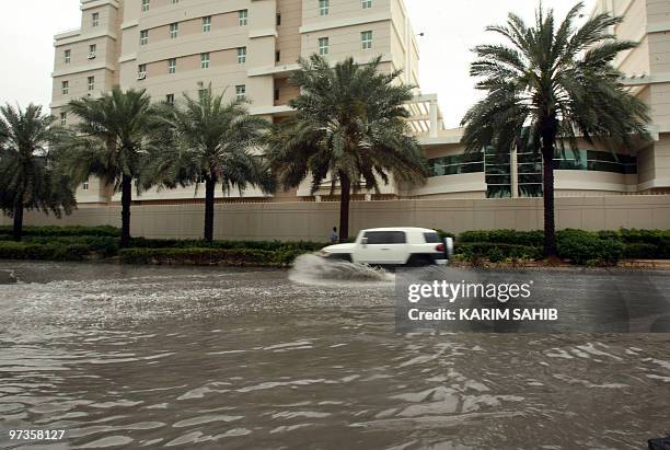 Four-wheel drive vehicle drives through a flooded street in Dubai's Internet City, following heavy rain on March 2, 2010. An unusual cold wave and...