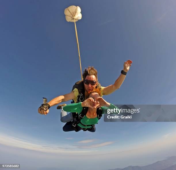 skydiving tandem heart sign - hands in the air heart stock-fotos und bilder