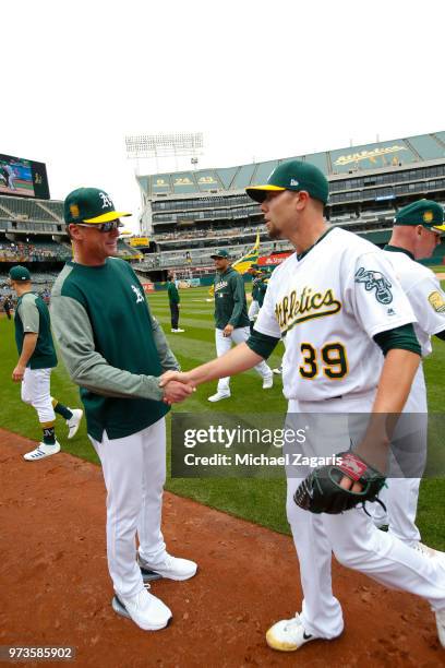 Manager Bob Melvin of the Oakland Athletics congratulates Blake Treinen on the field following the game against the Seattle Mariners at the Oakland...