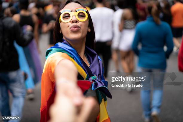 mädchen hand in hand und nach freund am straßenfest - pride fest stock-fotos und bilder