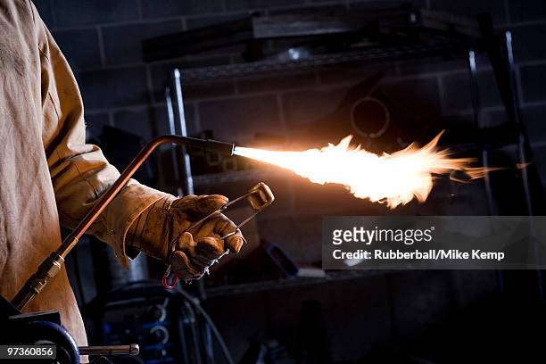 usa, utah, orem, male welder with blowtorch in workshop - in flames i the mask stock pictures, royalty-free photos & images