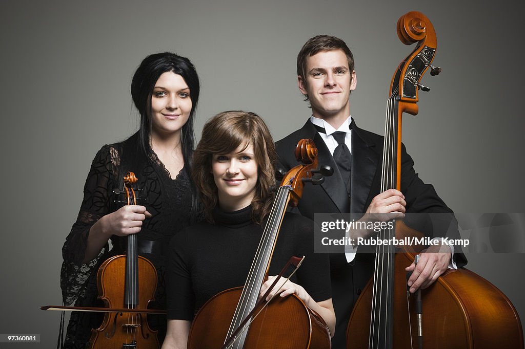 Studio portrait of three young musicians with instruments