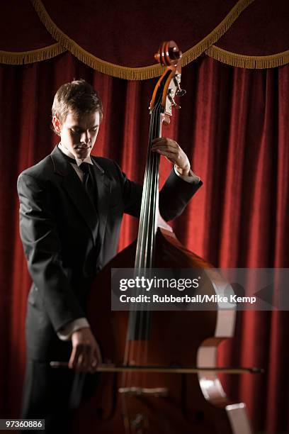 young man playing double bass - plucking an instrument - fotografias e filmes do acervo