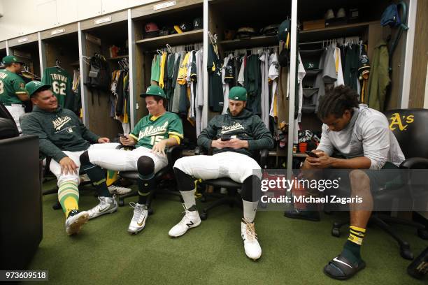 Bruce Maxwell, Emilio Pagan, Dustin Fowler and Khris Davis of the Oakland Athletics relax in the clubhouse prior to the game against the Arizona...