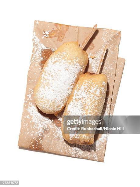 freshly fried donuts with powdered sugar on brown paper bag, studio shot - obesity epidemic stock pictures, royalty-free photos & images