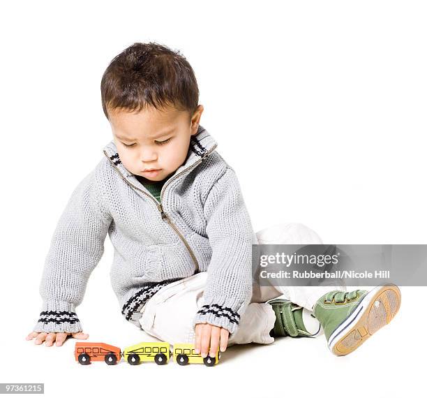 baby boy (18-23 months) playing with toy cars, against white background - 18 23 meses fotografías e imágenes de stock