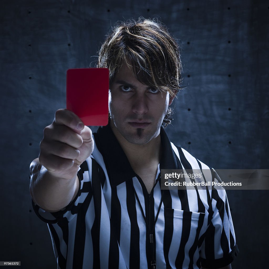 Studio shot of referee showing red card