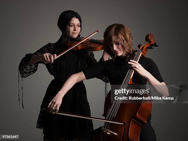 two young women playing string instruments - classical musician - fotografias e filmes do acervo