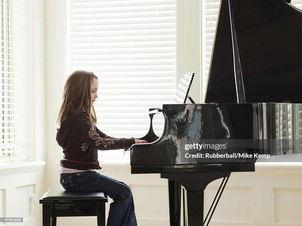 USA, Utah, Alpine, girl (8-9) practicing piano, side view