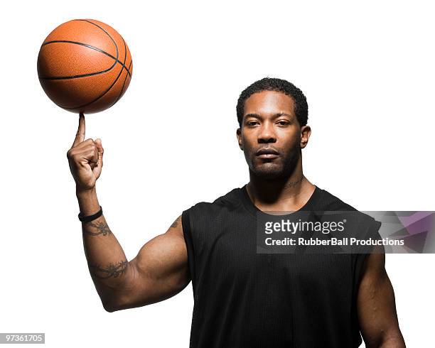 mid adult man spinning basketball in air, portrait - bras homme fond blanc photos et images de collection