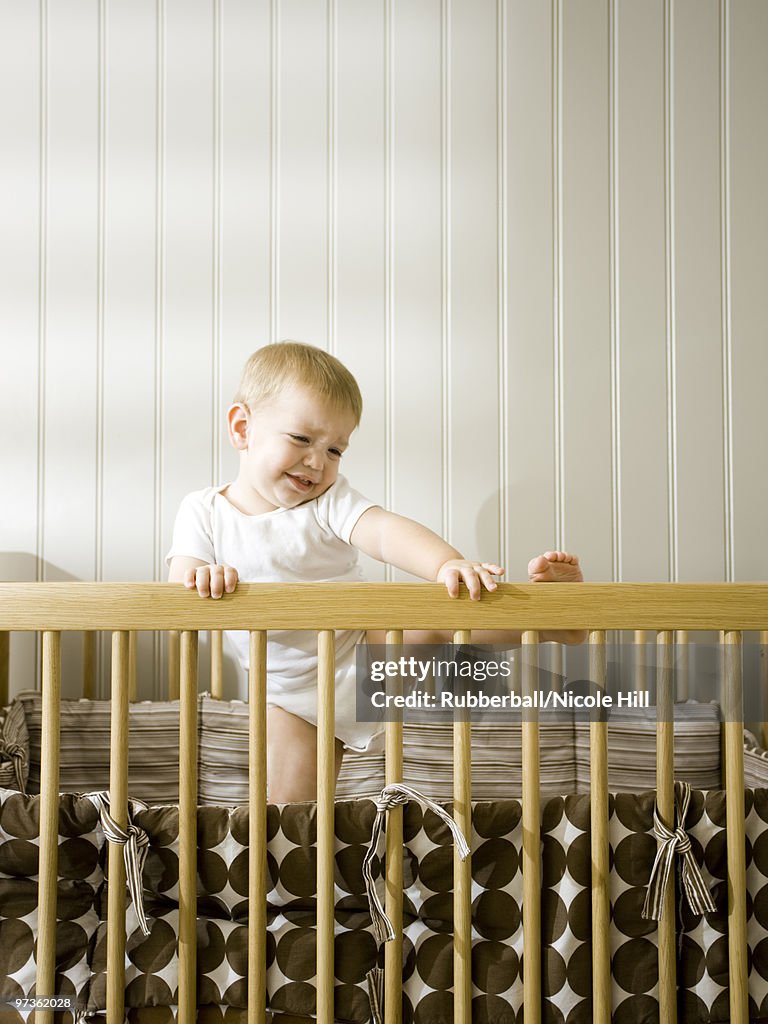 USA, Utah, Provo, Baby boy (18-23 months) climbing in crib