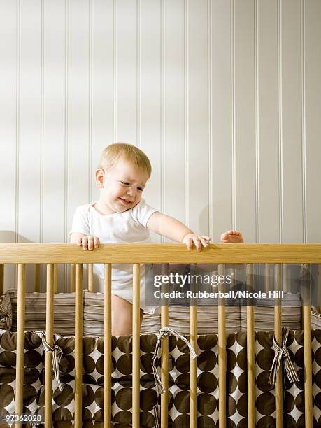 usa, utah, provo, baby boy (18-23 months) climbing in crib - 18 23 months stock pictures, royalty-free photos & images