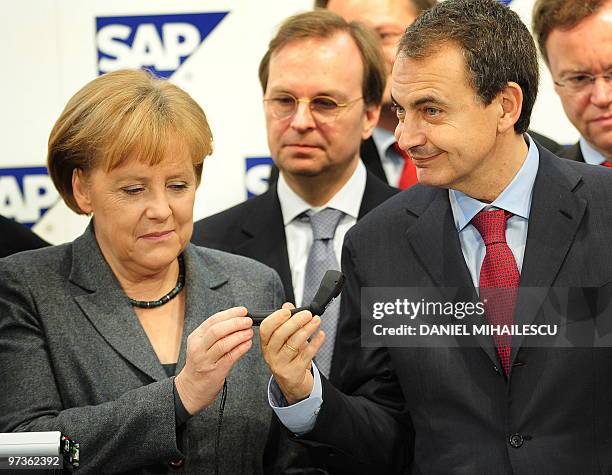 German Chancellor Angela Merkel and Spanish Prime Minister Jose Luis Rodriguez Zapatero inspects a "Head-Mounted Display" made by German software...
