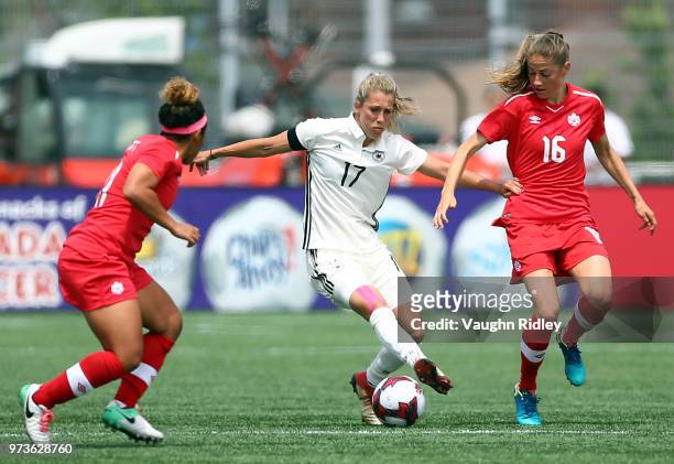 Verena Faibt of Germany battles with Desiree Scott and Janine Beckie of Canada during the first half of an International Friendly match at Tim...