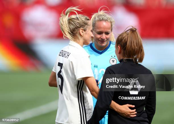 Kathrin Hendrich, Lisa Schmitz and Linda Dallmann of Germany speak to each other following the final whistle of an International Friendly match...